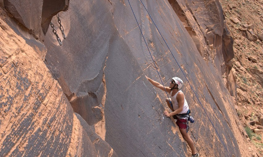 Rock climber on a climbing route known as Ice Cream Parlor in Moab, Utah.